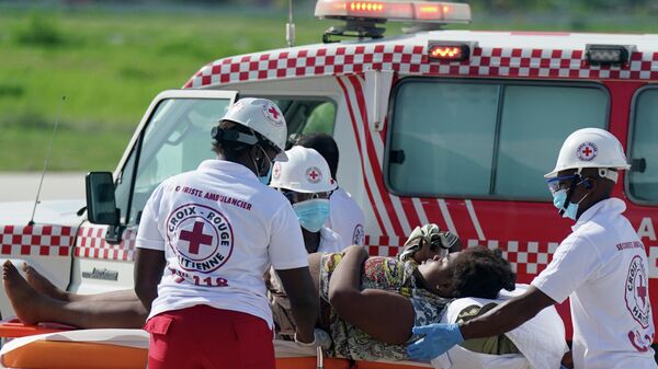 Работники скорой помощи увозят пострадавшего от землетрясения, Гаити