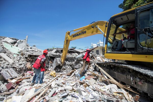 Спасатели работают на месте разрушенного дома после землетрясения, Гаити