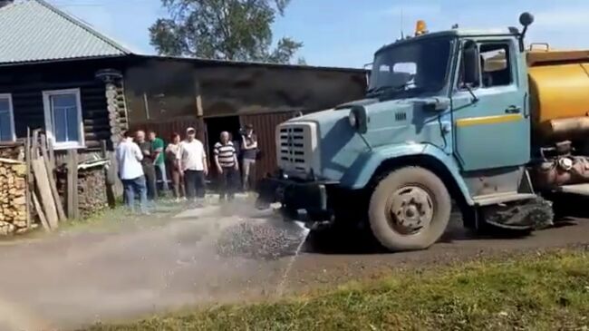 Поливомоечный автомобиль в частном секторе города Серов. Кадр видео