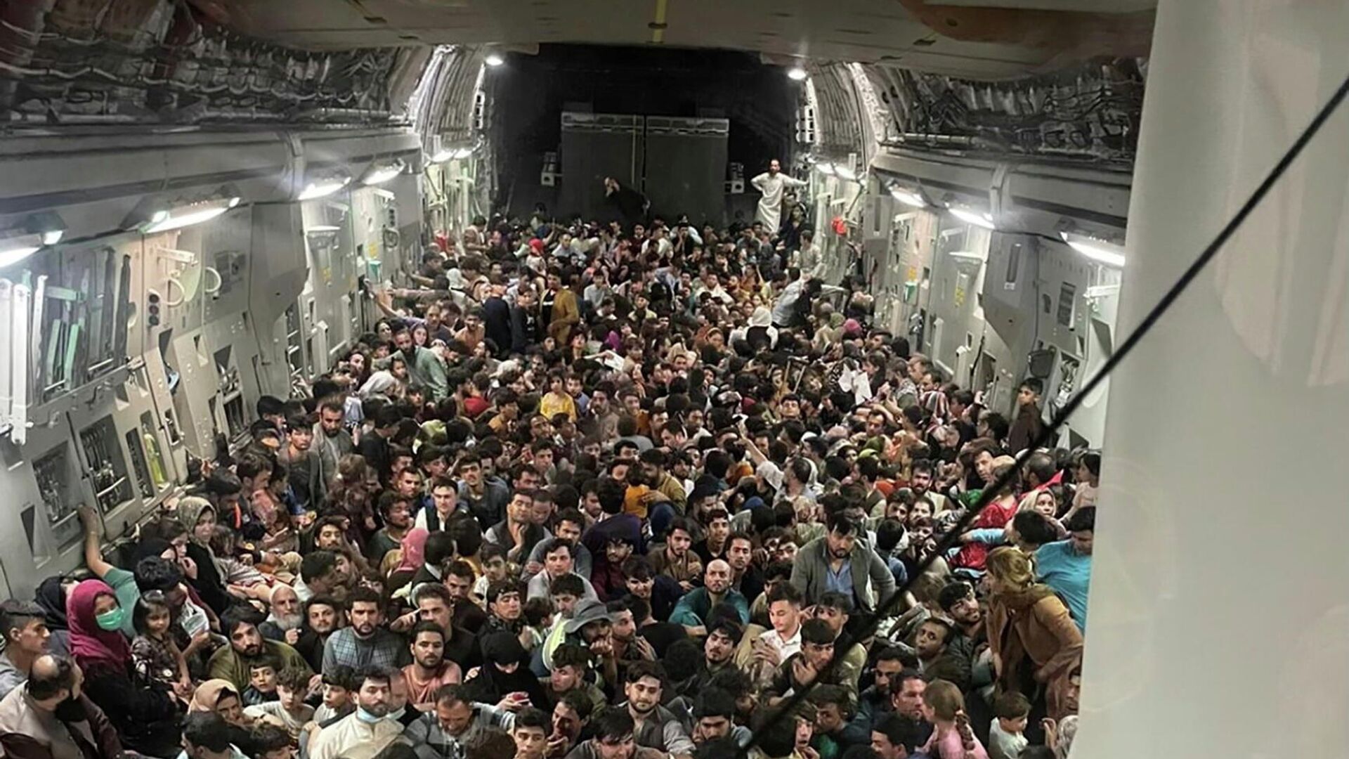 Люди внутри транспортного самолета C-17 Globemaster III ВВС США, перевозящего около 640 афганцев в Катар из Кабула, Афганистан, 15 августа 2021 - РИА Новости, 1920, 17.08.2021
