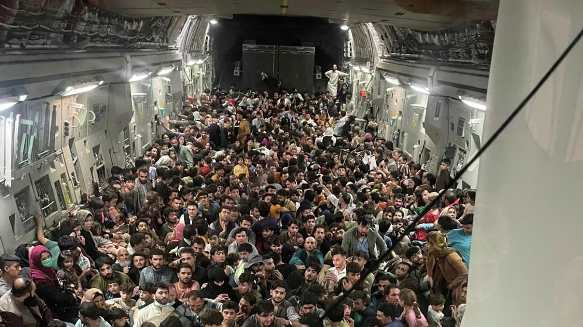 Люди внутри транспортного самолета C-17 Globemaster III ВВС США, перевозящего около 640 афганцев в Катар из Кабула, Афганистан, 15 августа 2021 - РИА Новости, 1920, 17.08.2021