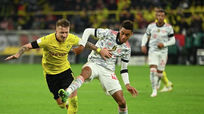 Dortmund's German forward Marco Reus (L) and Bayern Munich's German midfielder Jamal Musiala vie for the ball during the German Supercup football match BVB Borussia Dortmund vs FC Bayern Munich in Dortmund, on August 17, 2021. (Photo by Ina Fassbender / AFP) / DFL REGULATIONS PROHIBIT ANY USE OF PHOTOGRAPHS AS IMAGE SEQUENCES AND/OR QUASI-VIDEO