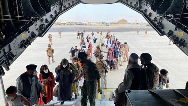 Граждане Испании, проживающие в Афганистане, и афганцы садятся в военный самолет в международном аэропорту в Кабуле, Афганистан
