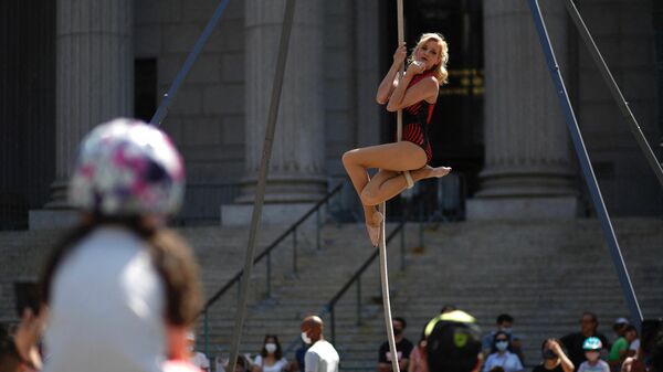 Акробат выступает на мероприятии Summer street в Нью-Йорке