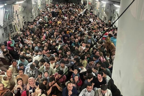 Люди внутри транспортного самолета C-17 Globemaster III ВВС США, перевозящего около 640 афганцев в Катар из Кабула