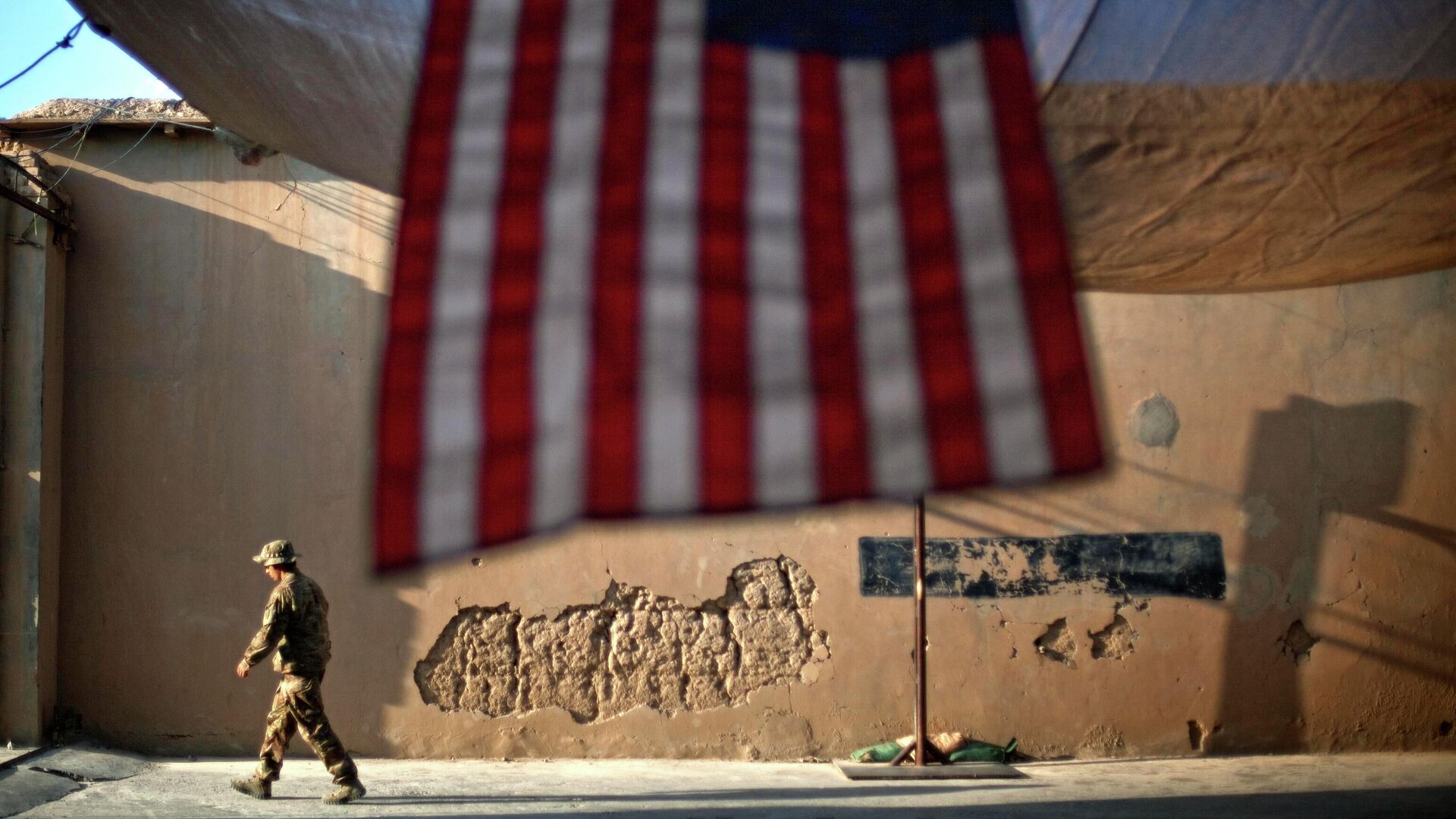 Солдат армии США проходит мимо американского флага на передовой оперативной базе Бостик в афганской провинции Кунар - РИА Новости, 1920, 20.08.2021