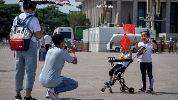 Дети держат китайские флаги, когда позируют для фото, Пекин