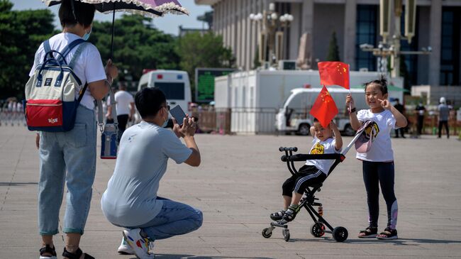 Дети держат китайские флаги, когда позируют для фото, Пекин