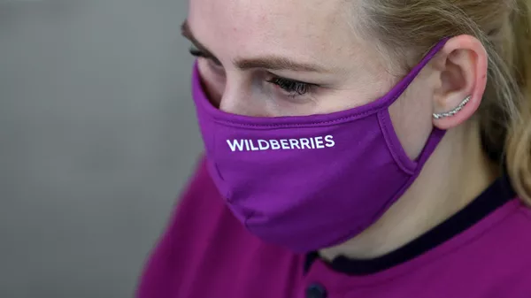 Сотрудник в защитной маске в пункте выдачи товара интернет магазина Wildberries в Москве