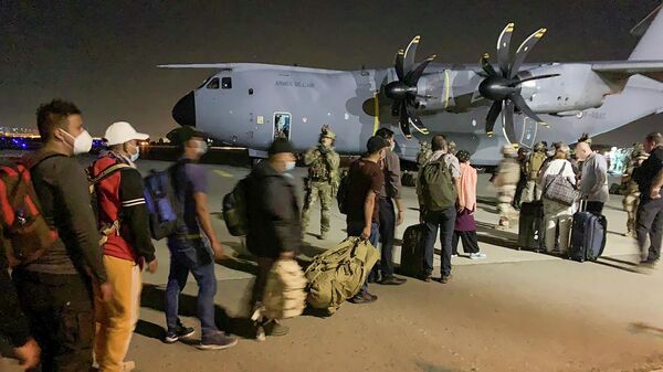 Люди ждут посадки на французской военный самолет в аэропорту Кабула, Афганистан 