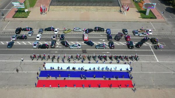 Участники автопробега и флешмоба в честь празднования Дня Государственного флага Российской Федерации в Луганске
