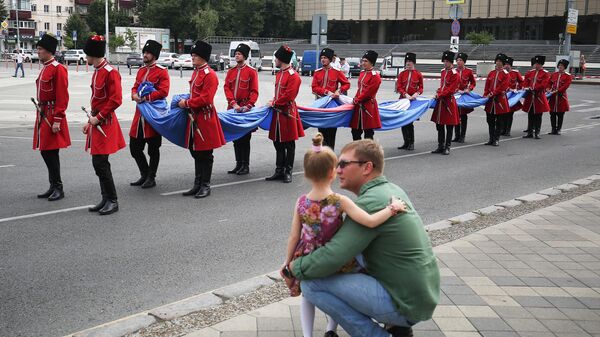 Почетный караул Кубанского казачьего войска готовится к поднятию государственного флага РФ на Главной городской площади Краснодара во время празднования Дня Государственного флага РФ. 