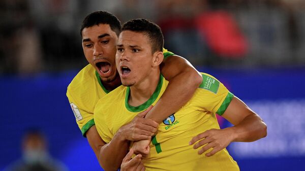 Игроки сборной Бразилии Лукао (слева) и Халк радуются забитому мячу в матче первого тура группового этапа чемпионата мира по пляжному футболу 2021 между командами Швейцарии и Бразилии.