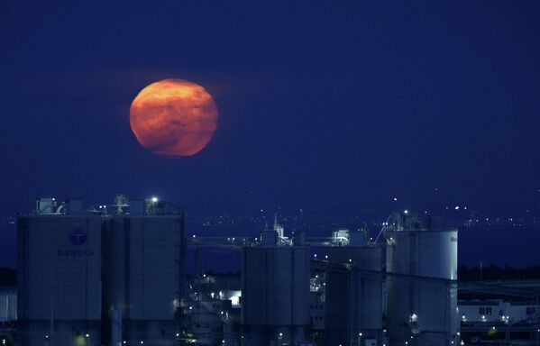 Полная луна поднимается над Токийским заливом в Токио, Япония