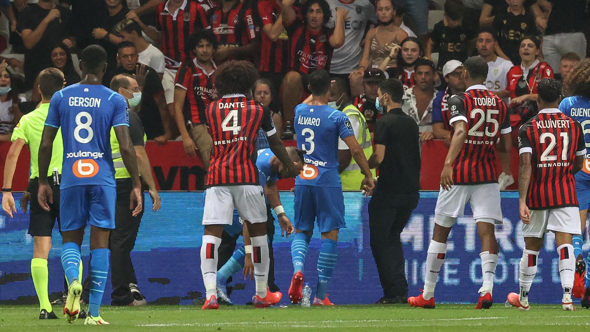 Marseille's Spanish defender Alvaro Gonzalez (C) speaks to Nice's supporters as Marseille's French midfielder Dimitri Payet (C-L) picks up a bottle of water on the pitch during the French L1 football match between OGC Nice and Olympique de Marseille (OM) at the Allianz Riviera stadium in Nice, southern France on August 22, 2021. - The French Ligue 1 game between Nice and Marseille was halted on August 22, 2021, when fans of the home side invaded the pitch and angrily confronted opposing player Dimitri Payet. An AFP journalist at the game said trouble flared in the 75th minute when Marseille star Payet, who had been targeted by plastic bottles every time he took a corner, lobbed one back into the stands. (Photo by Valery HACHE / AFP) - РИА Новости, 1920, 23.08.2021