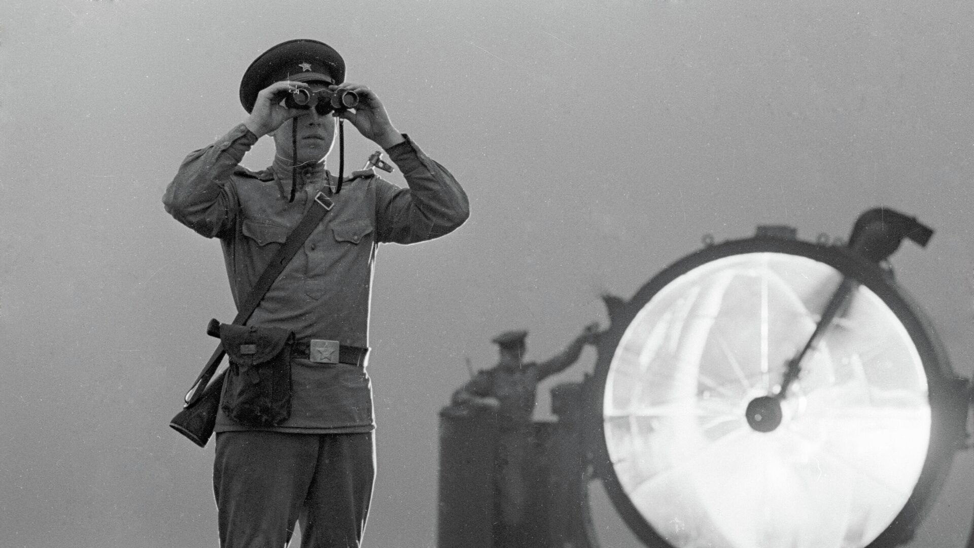 Пограничник смотрит в бинокль на пограничном посту у моря - РИА Новости, 1920, 25.08.2021