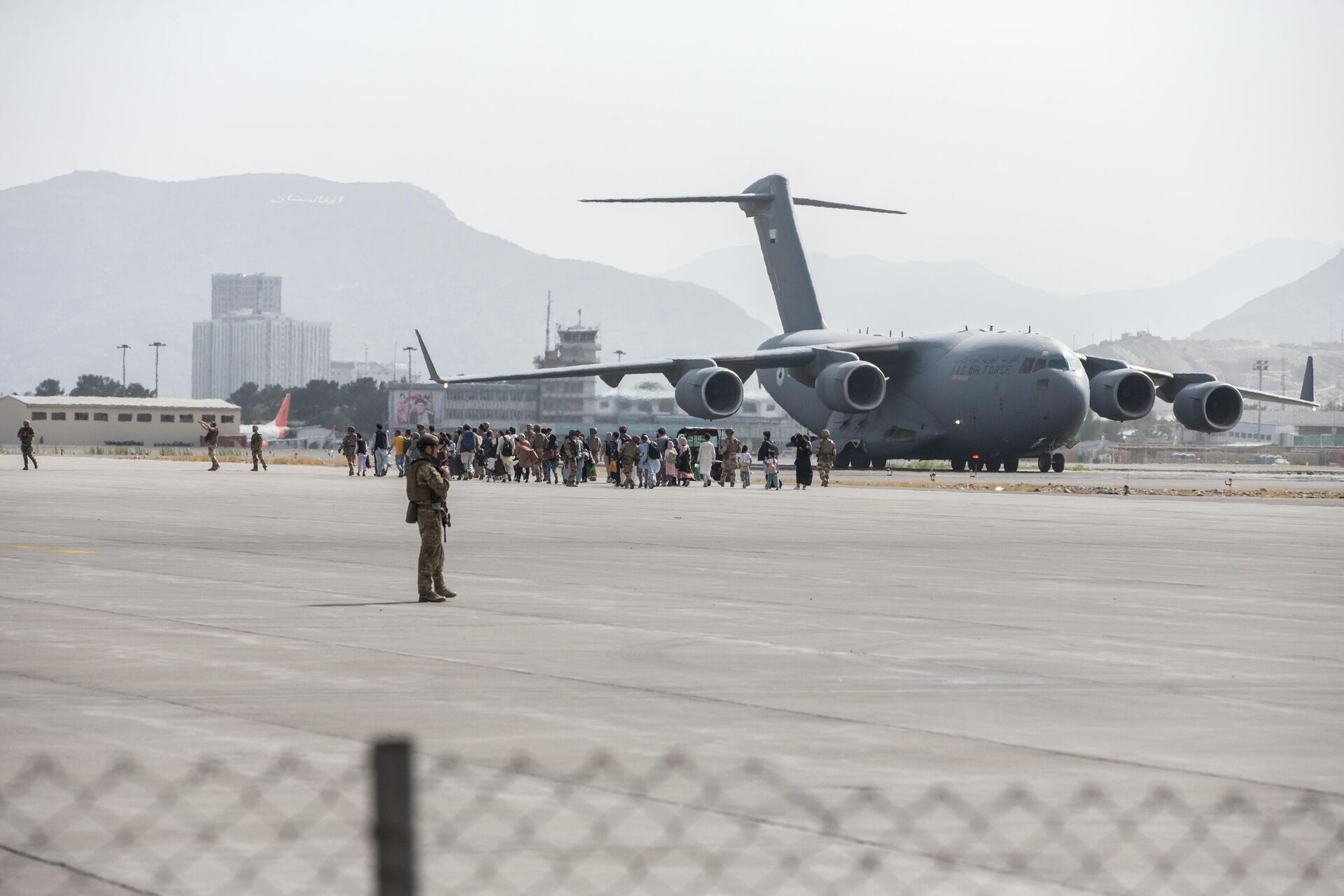 Очередь на посадку в самолет C-17 Globemaster III ВВС США во время эвакуации в аэропорту Кабула - РИА Новости, 1920, 13.12.2021