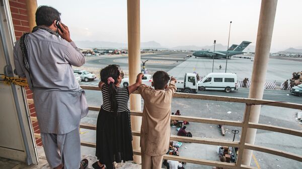 Афганская семья во время эвакуации в аэропорту Кабула
