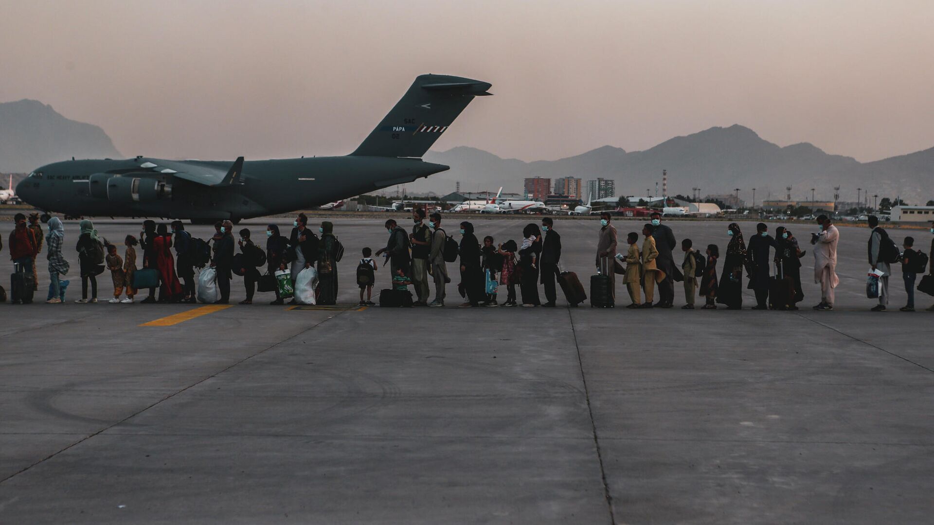 Очередь на посадку в самолет C-17 Globemaster III ВВС США во время эвакуации в аэропорту Кабула - РИА Новости, 1920, 26.08.2021