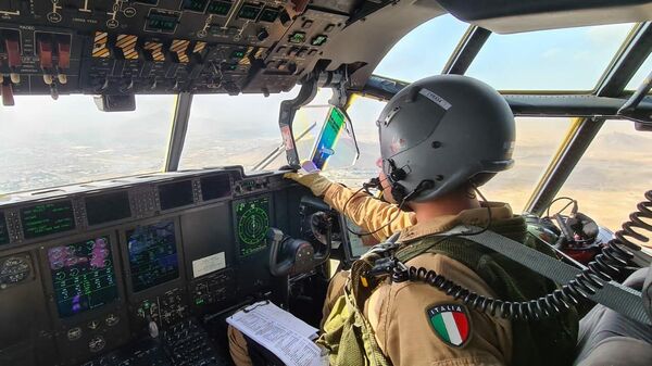 Пилот в кабине итальянского военного самолета с пассажирами, эвакуированными из Афганистана