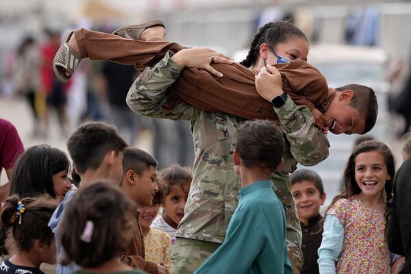 Американский солдат играет с эвакуированными афганскими детьми на авиабазе Рамштайн США в Германии
