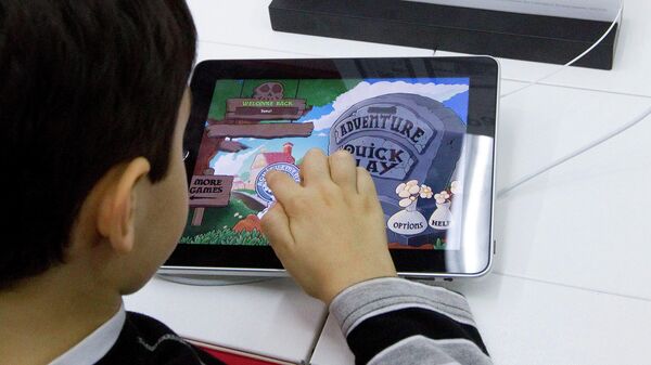 Мальчик играет в игру на планшетном компьютере 360