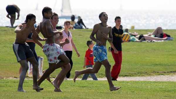 Молодые люди играют в футбол в парке Марселя, южная Франция