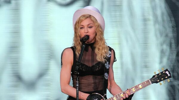 Мадонна во время выступления на Дворцовой площади в Санкт-Петербурге, на заднем фоне - Бритни Спирс