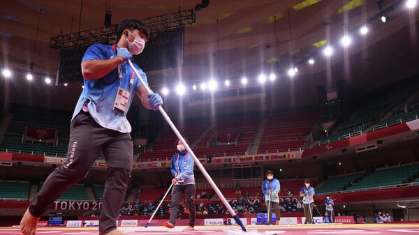 Сотрудник очищает маты на Паралимпийских играх в Токио