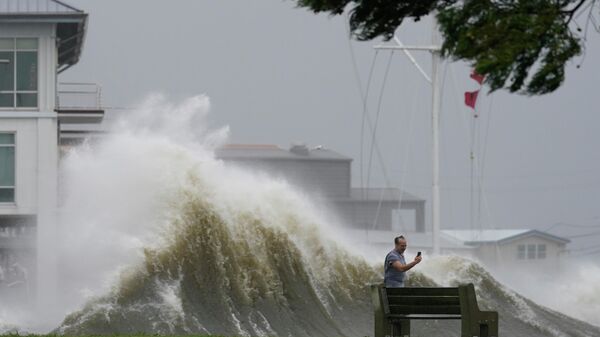 Мужчина фотографирует высокие волны во время приближения урагана