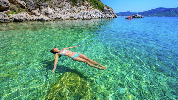 Девушка отдыхает на пляже Порто Тимони на Корфу
