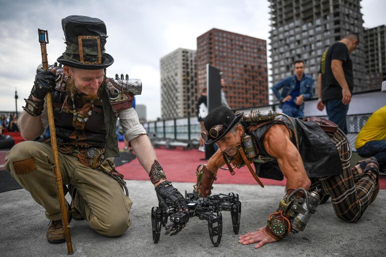 Аниматоры рассматривают робота-паука на фестивале науки и технологий Geek Picnic в Москве