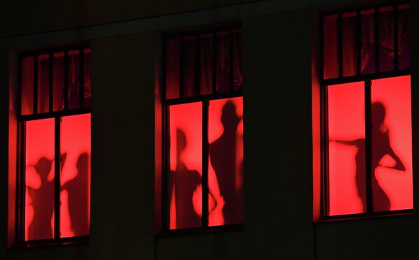 Силуэты танцовщиц и танцоров в окнах Дома офицеров на проспекте Мира в центре Красноярска