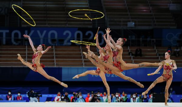 Российские спортсменки выполняют упражнения с тремя обручами и двумя парами булав в финале соревнований групп на XXXII летних Олимпийских играх в Токио