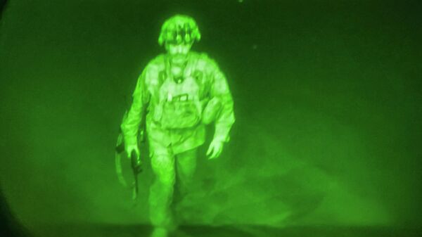 Генерал-лейтенант Крис Донахью  поднимается на борт с винтовкой в руках. Снимок сделан инфракрасной камерой 
