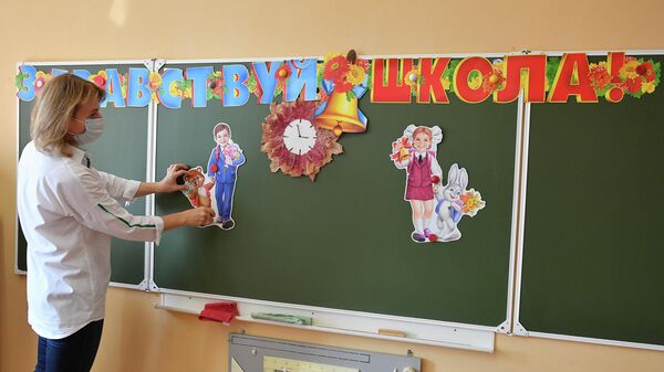 Учителя украшают доску в классе во время подготовки к новому учебному году