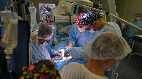 Врачи проводят операцию по удалению раковой опухоли головного мозга у пациентки в операционной Московского научно-исследовательского института онкологии имени П. А. Герцена