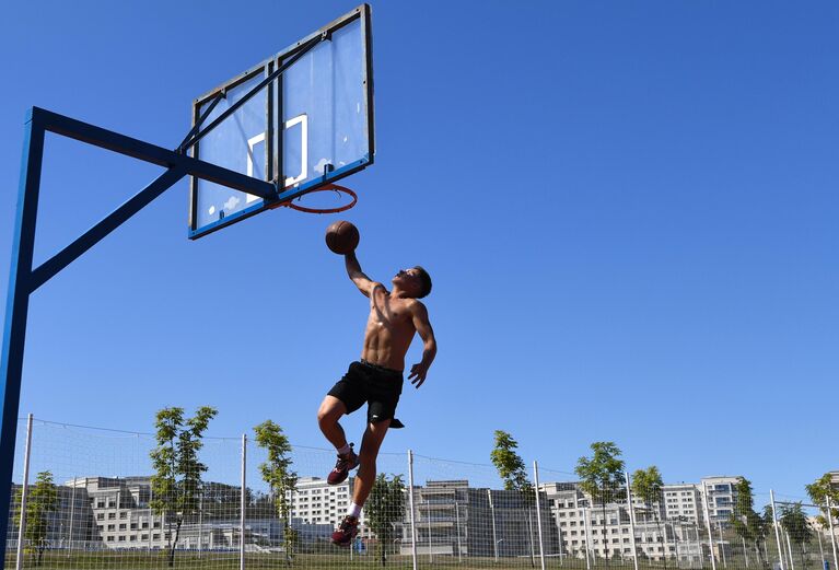 Студент играет в баскетбол на спортивной площадке в кампусе Дальневосточного федерального университета на острове Русский