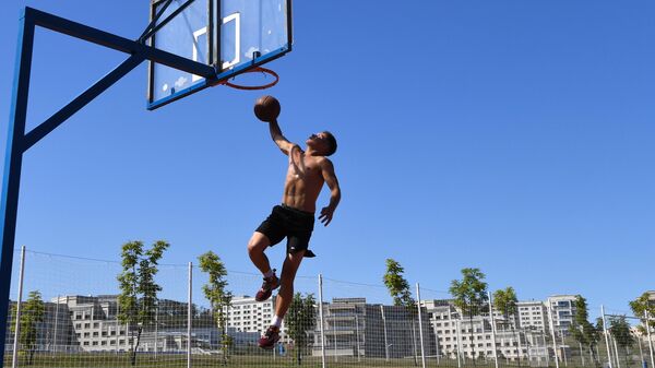 Студент играет в баскетбол на спортивной площадке в кампусе Дальневосточного федерального университета на острове Русский