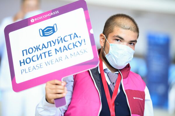 Волонтер с информационной табличкой на выставочной экспозиции в рамках Восточного экономического форума во Владивостоке