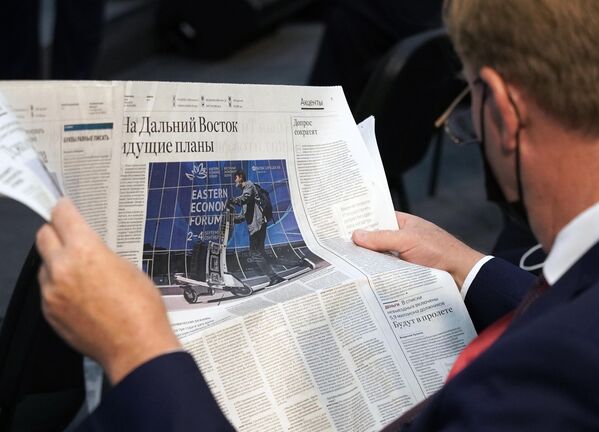Участник Восточного экономического форума во Владивостоке читает газету перед началом сессии