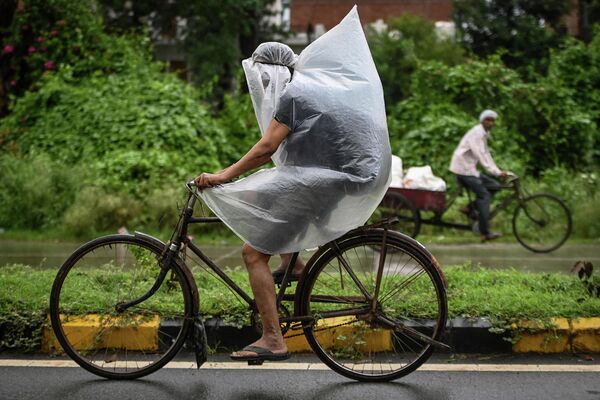 Велосипедист укрывается ливня в Фаридабаде 