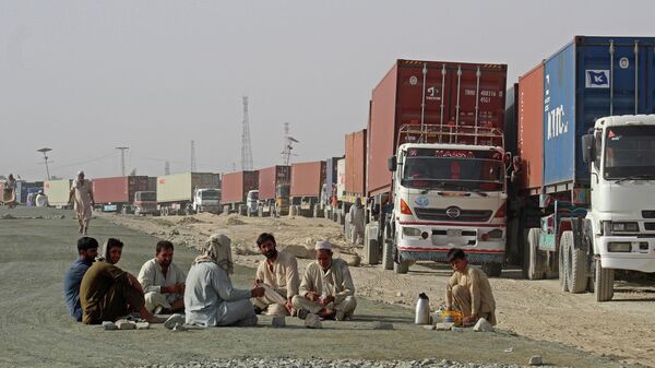 Водители сидят рядом со своими контейнеровозами, ожидая въезда в Афганистан в пограничном с Пакистаном городе Чаман 
