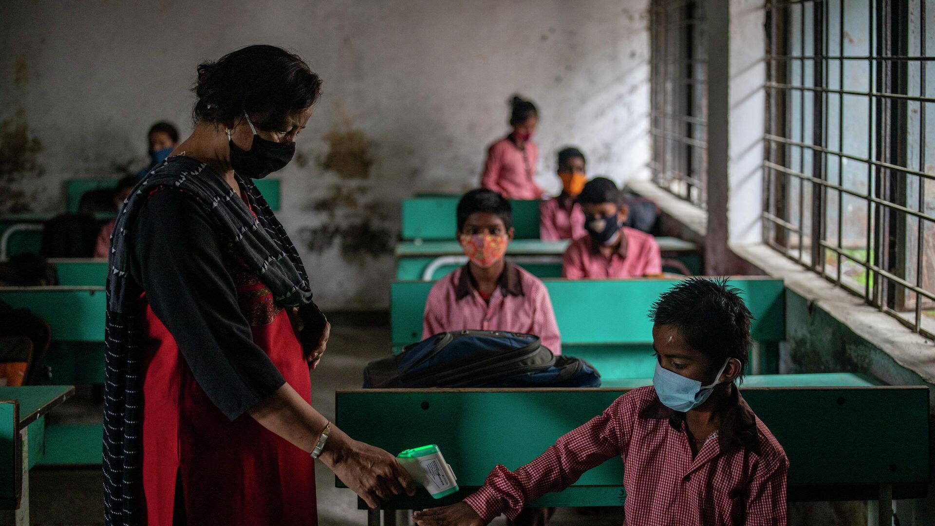 Учитель проверяет температуру тела ученика в первый день частичного открытия школ в Ноиде, пригороде Нью-Дели, Индия - РИА Новости, 1920, 18.09.2021