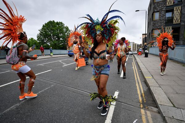 Люди в карнавальных костюмах на улице в Ноттинг-Хилле в Лондоне, Великобритания