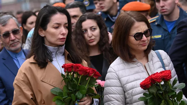 Женщины с цветами во время церемонии возложения цветов и венков к памятнику жертвам террористического акта в Беслане перед Храмом Рождества Пресвятой Богородицы на Кулишках в Москве