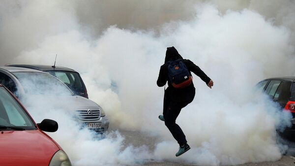 Мужчина в облаке слезоточивого газа во время акции против интронизации епископа Иоаники в Цетинье, Черногория