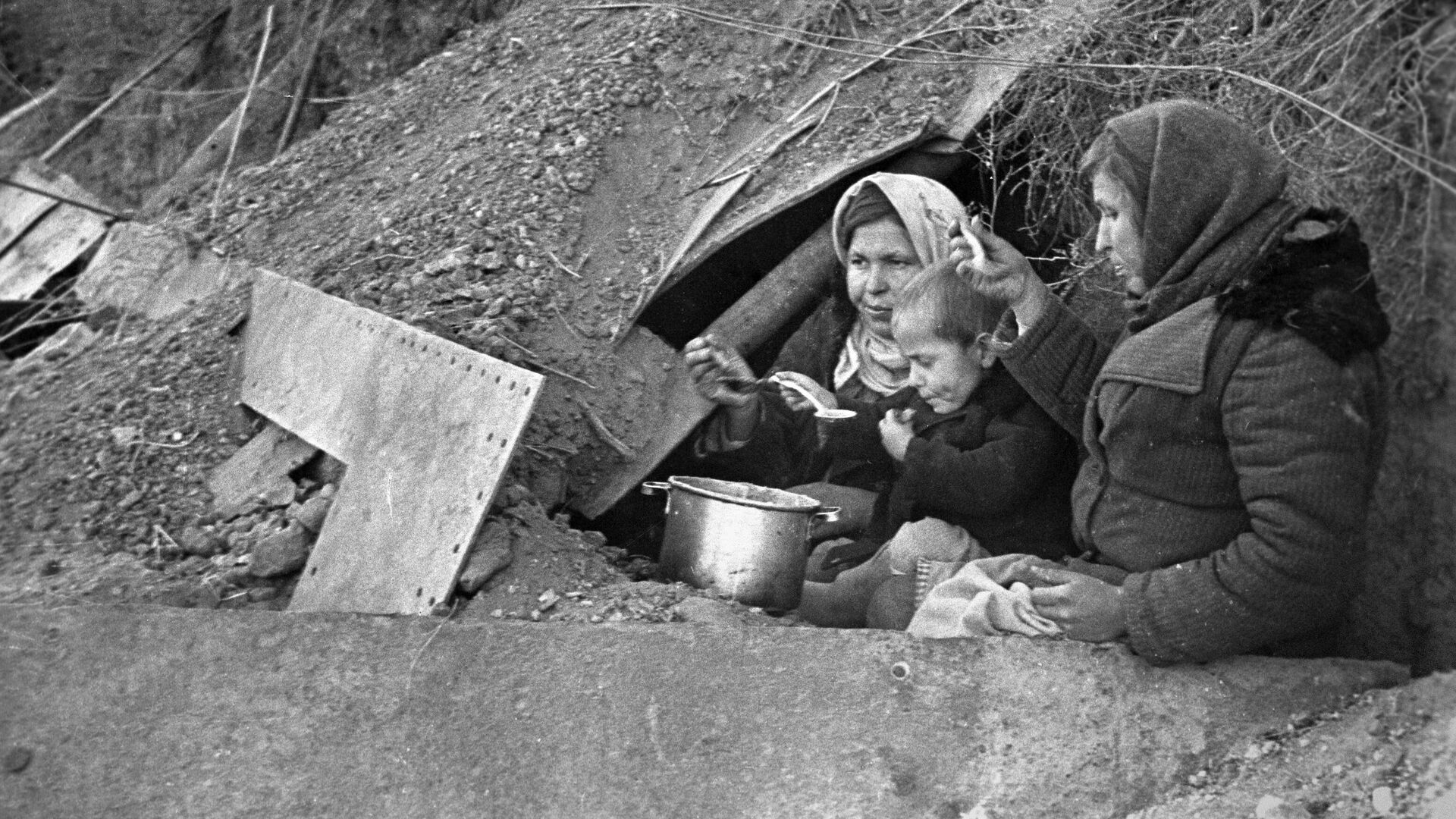 Оставшиеся без крова жители города у входа в землянку, приспособленную под жилье в Сталинграде - РИА Новости, 1920, 26.11.2021