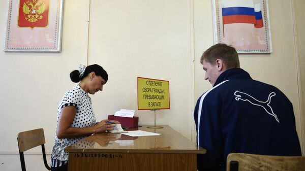 Сотрудница отдела военного комиссариата Новосибирской области во время работы с гражданами, пребывающими в запасе
