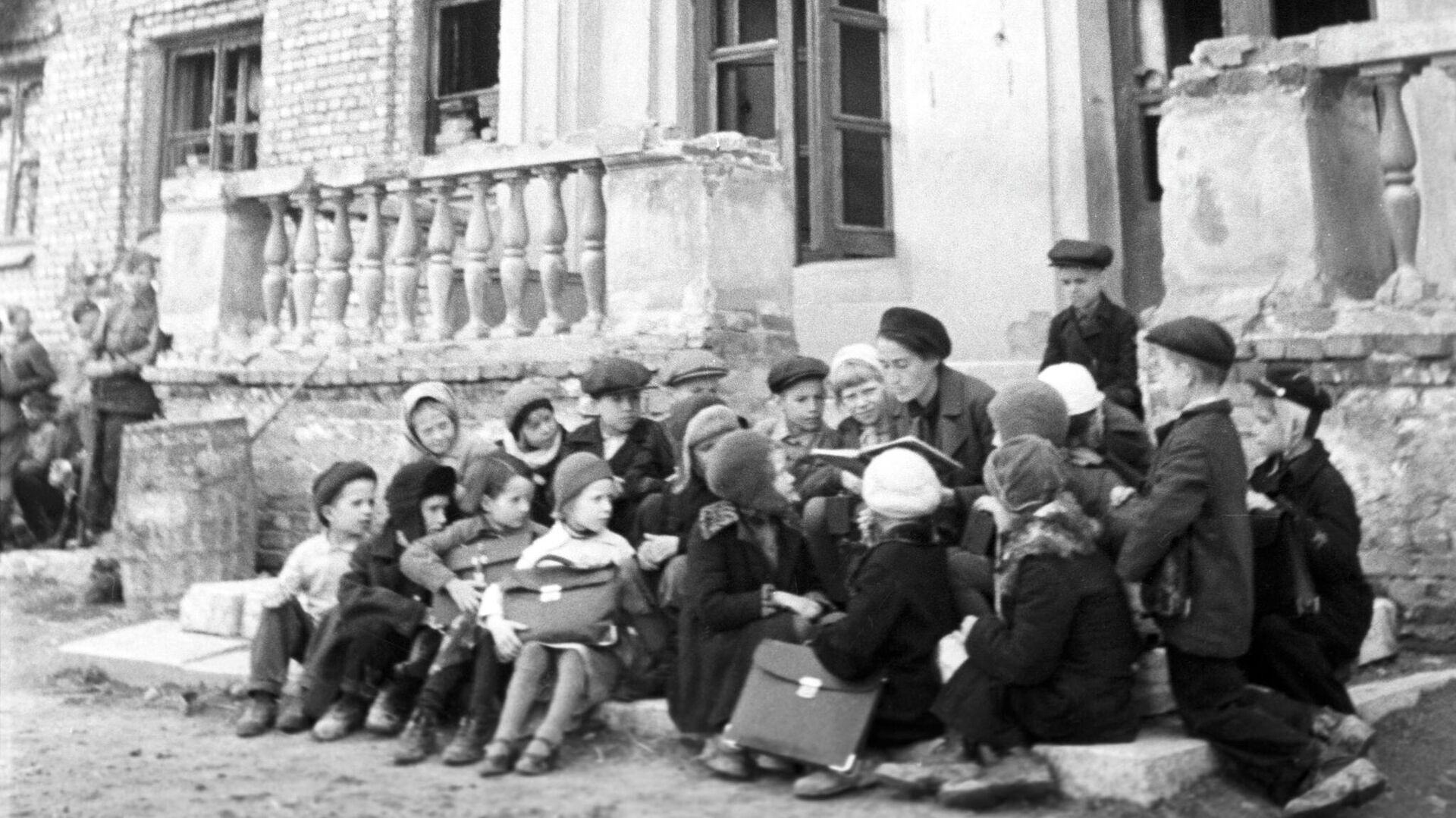 Урок на крыльце разрушенной немецкими обстрелами школы - РИА Новости, 1920, 20.10.2022